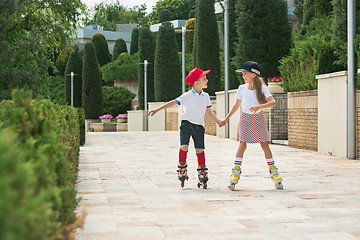 Image showing Portrait of a charming teenage couple roller-skating together