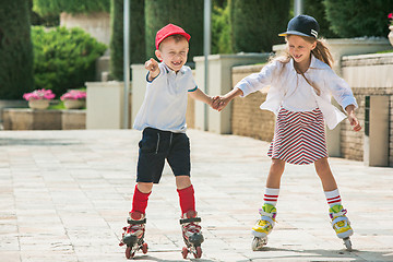 Image showing Portrait of a charming teenage couple roller-skating together