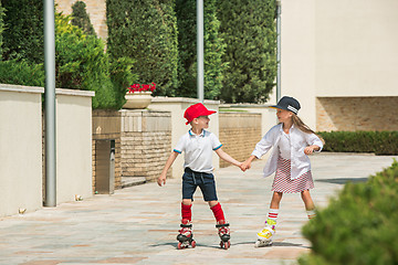 Image showing Portrait of a charming teenage couple roller-skating together