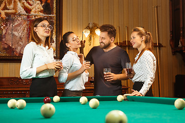 Image showing Young men and women playing billiards at office after work.