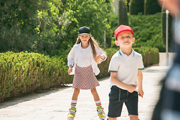 Image showing Portrait of a charming teenage couple roller-skating together