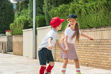 Image showing Portrait of a charming teenage couple roller-skating together