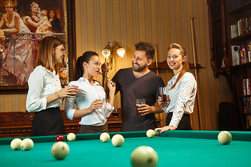 Image showing Young men and women playing billiards at office after work.