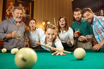 Image showing Young men and women playing billiards at office after work.