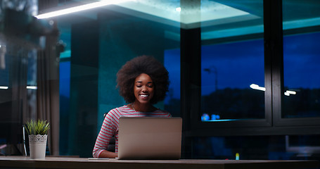 Image showing black businesswoman using a laptop in night startup office