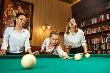 Image showing Young women playing billiards at office after work.