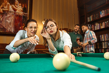 Image showing Young men and women playing billiards at office after work.