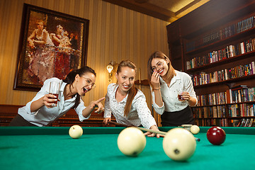 Image showing Young women playing billiards at office after work.