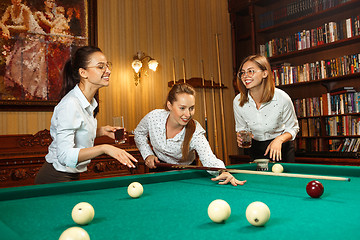 Image showing Young women playing billiards at office after work.