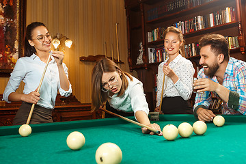 Image showing Young men and women playing billiards at office after work.