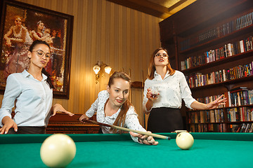 Image showing Young women playing billiards at office after work.