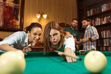 Image showing Young men and women playing billiards at office after work.