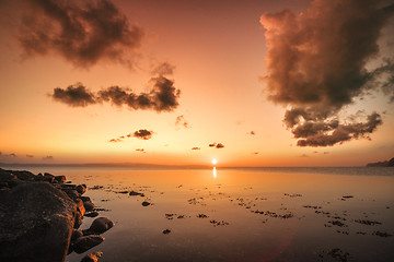 Image showing Sunrise over the sea by the shore with rocks