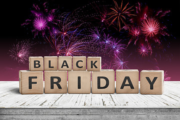 Image showing Black friday sign on a wooden table with fireworks