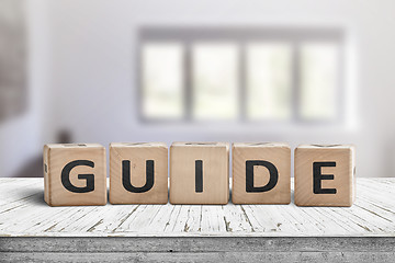 Image showing Guide sign made of wood on a desk in a bright room