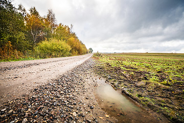 Image showing Puddle by a dirt road with small pebbles in the fall