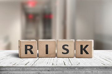 Image showing Risk sign on a wooden desk with red lights