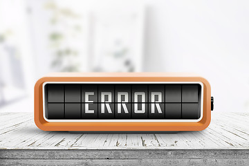 Image showing Error message on a wooden desk with a retro alarm