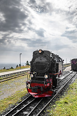 Image showing Black locomotive with red color driving on a railtrack