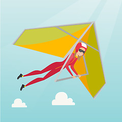 Image showing Young caucasian woman flying on hang-glider.