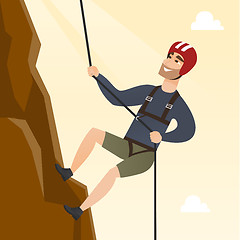 Image showing Young caucasian man climbing a mountain with rope.