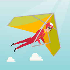Image showing Young caucasian man flying on hang-glider.