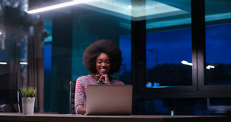 Image showing black businesswoman using a laptop in night startup office