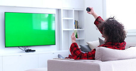 Image showing Young couple on the sofa watching television