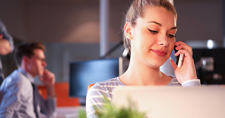 Image showing woman using mobile phone in dark office