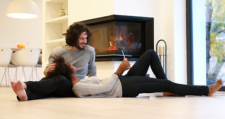 Image showing Young Couple using digital tablet on the floor