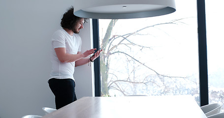 Image showing young man using a tablet at home