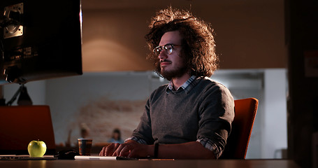 Image showing man working on computer in dark office