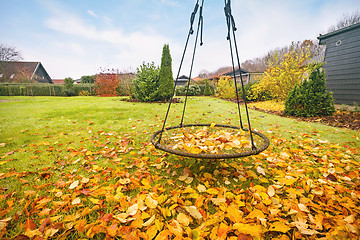 Image showing Swing covered with autumn leaves in golden colors