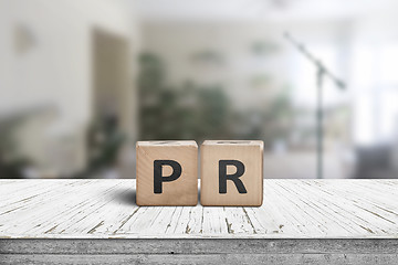 Image showing PR sign on a worn table in a bright room