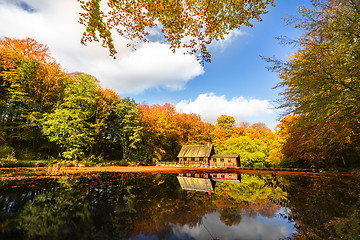 Image showing Little red house by a forest lake in the fall