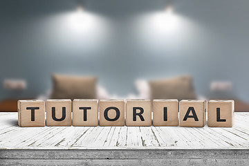 Image showing Tutorial sign on a wooden table in a room with lights