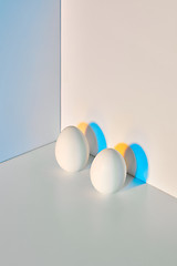 Image showing Two eggs are presented on a triple gray-blue beige background with a reflection of shadows and space for text. Easter.