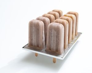 Image showing Cold chocolate dessert on a stick in plastic form on a white bac