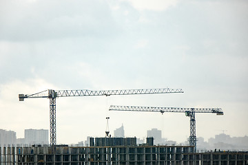 Image showing Industrial landscape with silhouettes of cranes on the gray cloudy background.