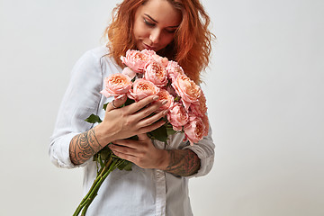 Image showing the girl is holding a bouquet of pink roses
