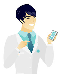 Image showing Young asian doctor holding a mobile phone.