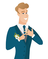 Image showing Cheerful groom showing golden ring on his finger.