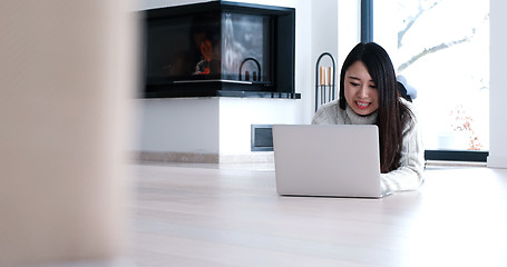 Image showing Asian woman using laptop on floor