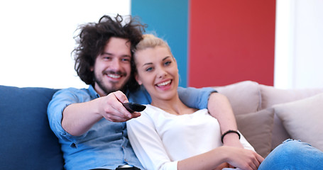 Image showing Young couple on the sofa watching television