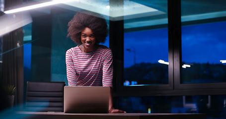 Image showing black businesswoman using a laptop in night startup office