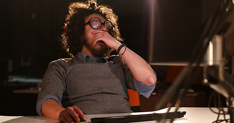 Image showing man working on computer in dark office