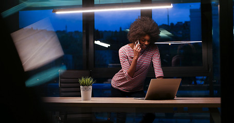 Image showing black businesswoman using a laptop in night startup office