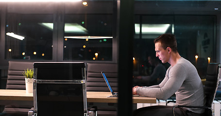 Image showing man working on laptop in dark office