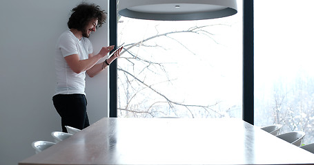 Image showing young man using a tablet at home