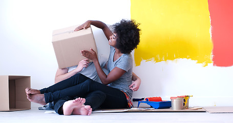 Image showing young multiethnic couple playing with cardboard boxes